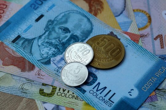 Costa Rican colon money bills and coins on table. Costa Rica cash of CRC currency close up