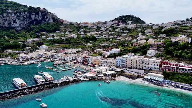 Capri Island and Marina Grande. Aerial 4K drone video footage with panorama of scenic Mediterranean coastline with luxury harbor and Italian seaside views