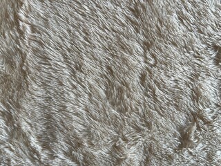 Soft fluffy faux fur carpet texture background. White cream shaggy rug surface pattern for interior design backdrop, cozy winter textile fashion luxury style, and cosmetic mockup. © FaizZakiy