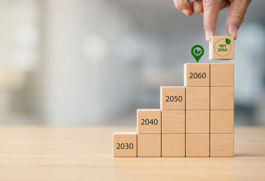 Net zero by 2060. Carbon neutral. Sustainalble development. Successful execution of green business. Goal checked in 2060. Go green company culture. Hand puts wooden cube with net zero icon, copy space