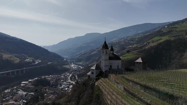 Forward Drone Flight Over Vineyards Toward Church Dome in Chiusa, South Tyrol, Italian Alps