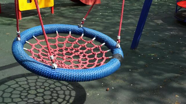 Blue nest swing sways gently, casting a patterned shadow below