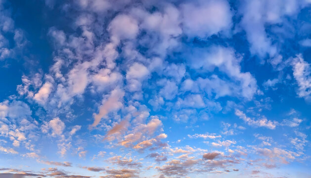 A dramatic sunset in evening colors of orange, red, and blue detailed parts. The edge forest on the shore separates the sky water. A breathtaking picture celestial interplay of warm and cool tones.