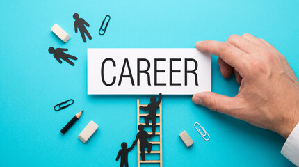 Fototapeta premium Hand holds CAREER sign above ladder. Mini figures climb toward success. Tools scatter around symbolic workspace