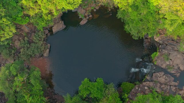 Aerial top down view of beautiful tropical waterfall and natural rock pool in green jungle 4K