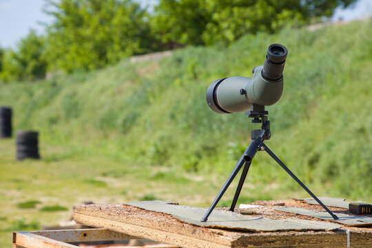 Monocular telescope on a tripod on a background of green grass.