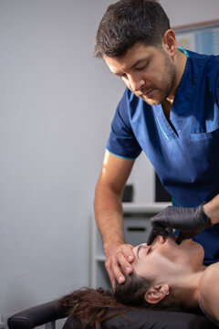 Specialist performing intra-oral physiotherapeutic jaw treatment