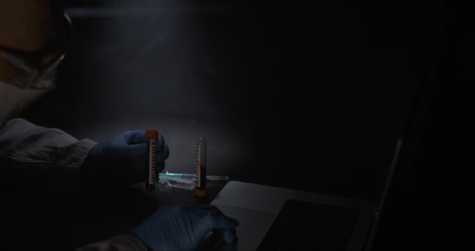 Researcher Meticulously Arranges Test Tubes And Chemicals On Lab Bench With Controlled Lighting