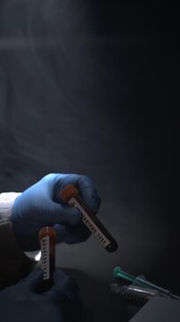 Laboratory Sample Handling. Hands Sorting Labeled Vials On Dark Surface Accurately And Carefully