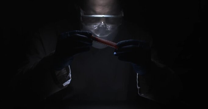Systematic Forensic Investigator Carefully Analyzes Minute Evidence Sample With Gloves And Focused Lighting