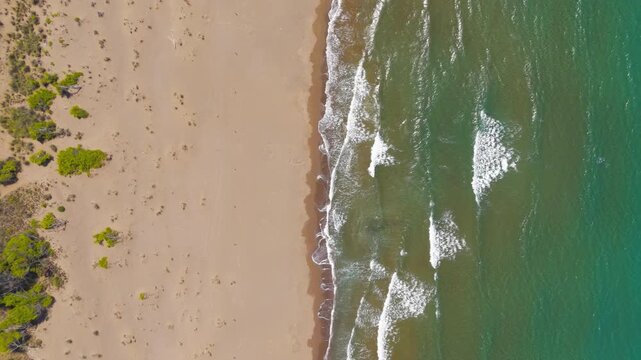 Dalyan, Turkey. Iztuzu Beach, a narrow 4.5 km sand spit between the Dalyan River delta and turquoise Mediterranean surf, with powerful waves rolling onto golden shoreline under bright summer sun. Aer