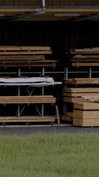 Wood Storage Scene. Openair Workshop In Countryside With Organized Wooden Beams And Shaded Roofing
