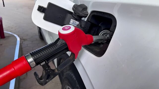 Video of a car being refueled. A nozzle is inserted into the car's gas tank.