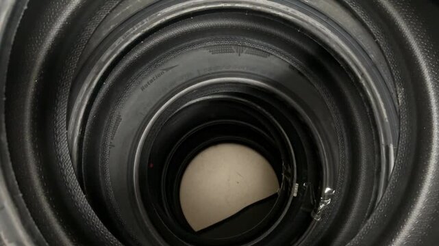 Stacked summer tires top view showing concentric inner wells and speckled rubber texture, close-up overhead shot of new passenger