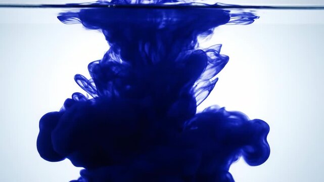 Blue Ink Drop in Water: A mesmerizing abstract image captures the moment dark blue ink disperses and swirls within clear water.