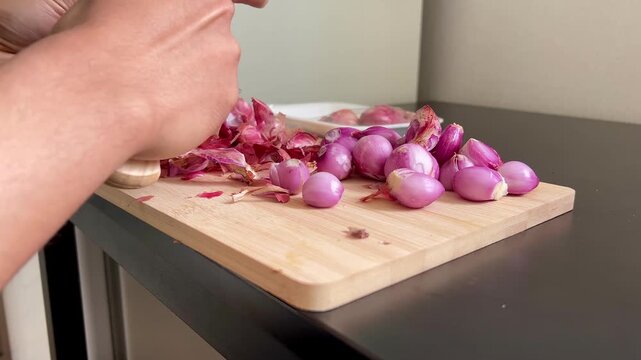 woman hands with onions, hands peeling red raw shallots 