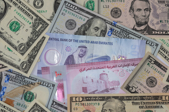 United Arab Emirates dirham and US dollar banknotes in a financial cash money background concept
