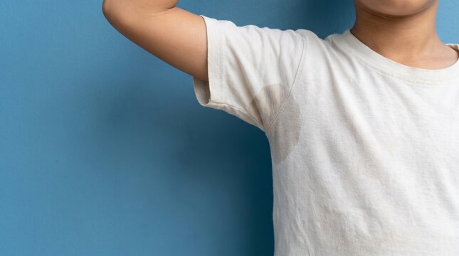 Close-up of a sweat stain on the armpit of a young boy wearing a white t-shirt