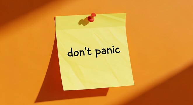 Yellow sticky note with the text dont panic pinned on an orange background