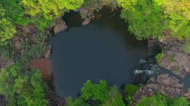 Aerial top down view of beautiful tropical waterfall and natural rock pool in green jungle 4K