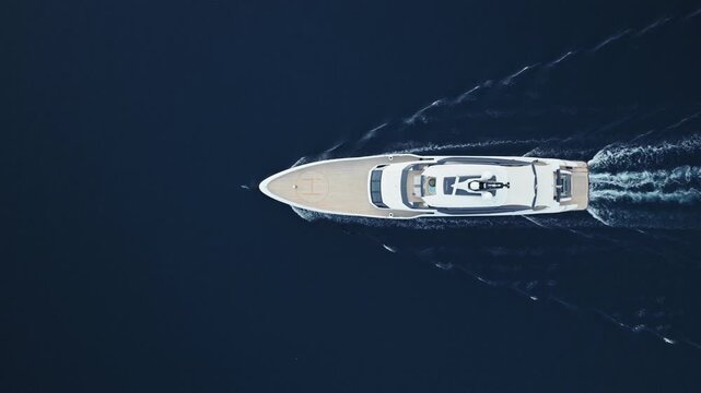 aerial top down view of superyacht with dolphin playing at bow in Bay of Kotor, Montenegro