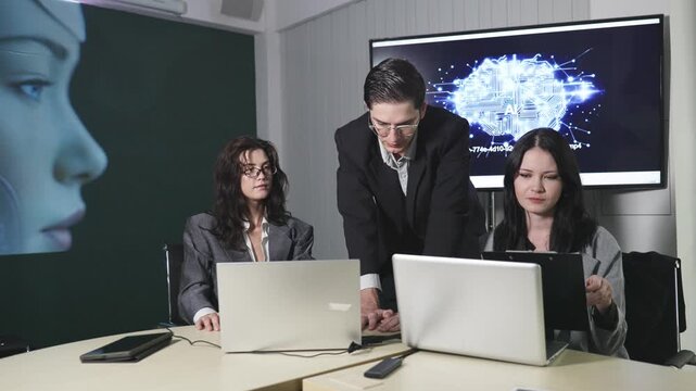 Three professionals in a business meeting setting with laptops, focused on a screen showing an AI-themed digital brain graphic and code.
