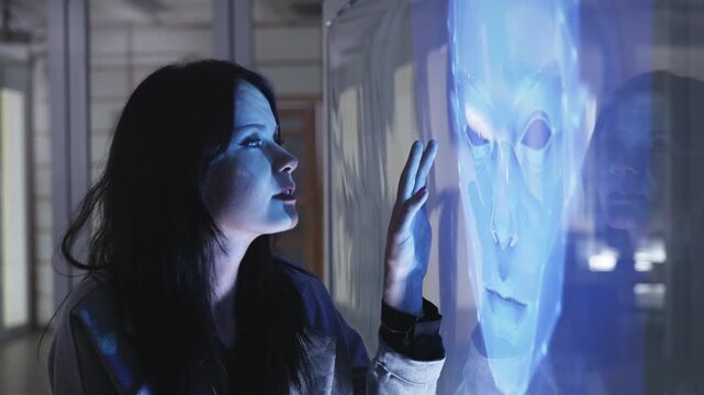 Businesswoman touches a glowing blue holographic brain diagram on a transparent screen, symbolizing AI, neuroscience, or digital intelligence technologies.