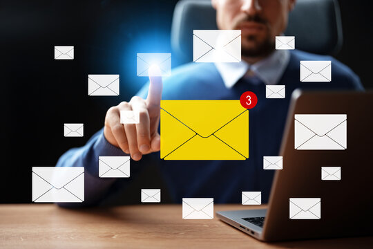 User interacts with email notifications while working on a laptop in an office setting