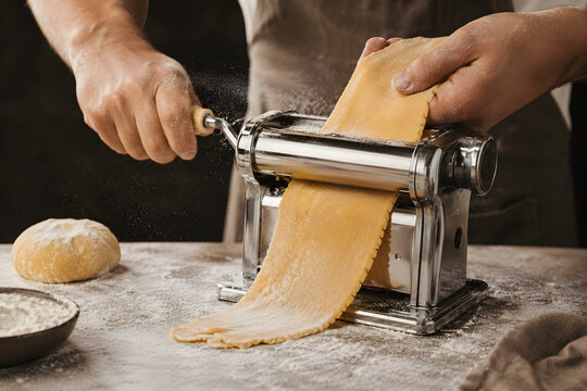Chef Preparing Fresh Homemade Pasta Dough With Traditional Pasta Maker