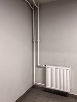 Vertical Heating Pipes and Radiator on Minimalist Wall