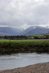 Fototapeta premium River Spey flowing through valley with Lairig Ghru mountain pass in background, Aviemore, Scotland