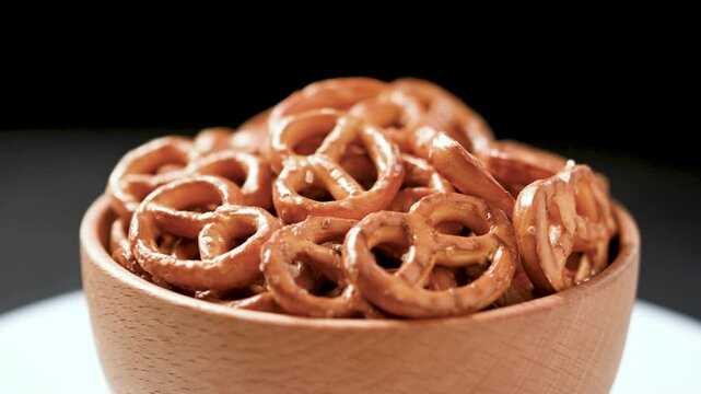 Rotating bowl of pretzels on table close up snack food concept