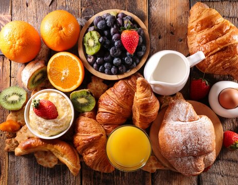 assorted breakfast pastries and fresh fruit on rustic table