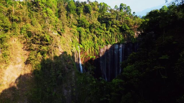Cinematic aerial view of Tumpak Sewu Waterfall in East Java &ndash; Breathtaking drone shot of majestic canyon water cascades in morning mist, premium Indonesia tourism landscape 4k footage