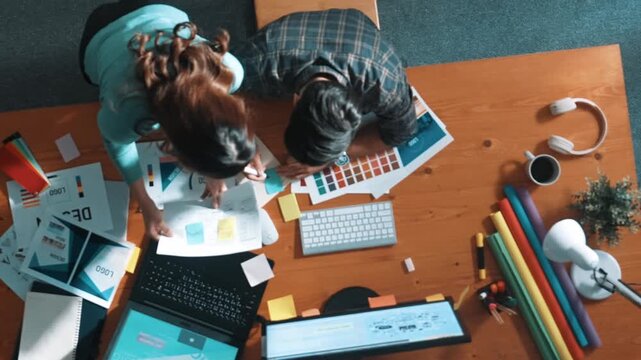 Top view of project manager looking at screen while designer writing idea. Close up of smart business team explain idea of logo design while designer choose theme while looking at palette. Symposium.