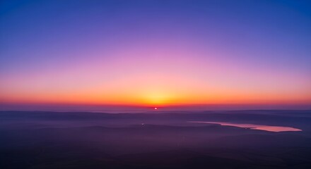 Fototapeta premium Breathtaking sunrise over the sea of galilee in israel, featuring a vibrant purple and orange sky with misty hills and calm water in the distance