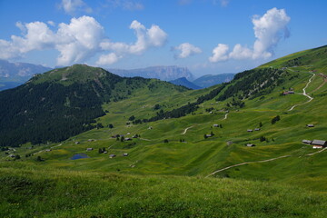 Naklejka premium Wide Alpine Landscape with Hills and Huts