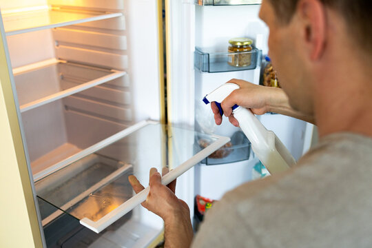Cleaning inside a refrigerator using cloth for hygiene and organization. closeup of technician meticulously cleaning and sanitizing refrigerator surfaces and compartments.