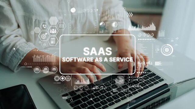 Hands typing on laptop with digital overlays representing SaaS, software as a service in modern workspace setting for technology concepts. Asymptotic smart data analytic.