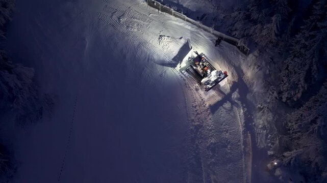 Nighttime Snow Grooming With Blue Lights. Remote Forest Slope Groomed Under Cold Illumination