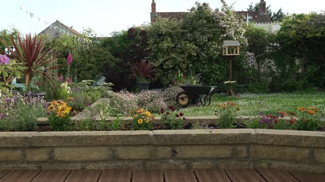Peaceful garden with wheel barrow and bird table.