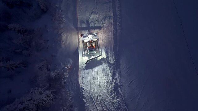 Dusk Snow Track Maintenance. Aerial Perspective Of Groomer Creating Neat Lines In Snow During Evening