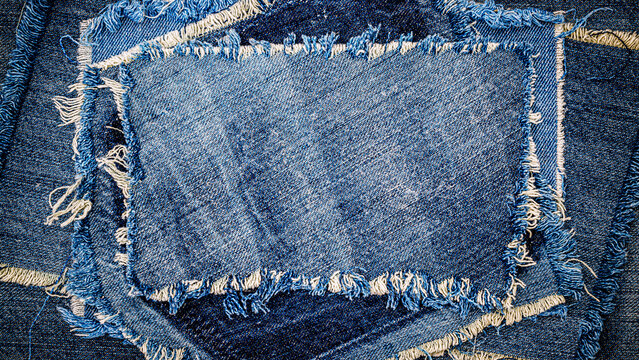 Different pieces of denim fabric laid out in an abstract design on a flat surface for textile display
