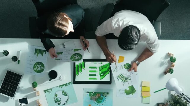 Top down view of business man presenting sustainable idea to manager by using tablet display ESG environmental social governance. Manager working together planning to use clean energy. Alimentation.