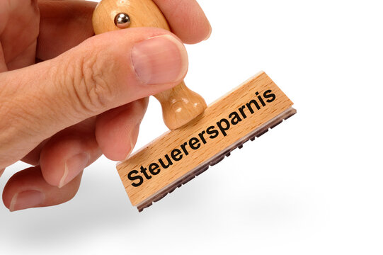 Ein Holzstempel ist bedruckt mit der Aufschrift: Steuerersparnis