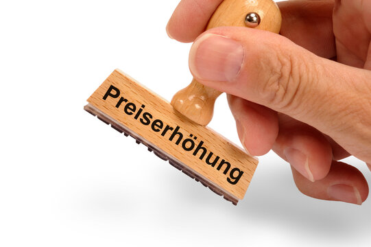 Ein Holzstempel ist beschriftet mit dem Aufdruck: Preiserh&ouml;hung