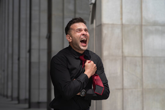 Desperate businessman clutching chest and screaming in pain with copy space