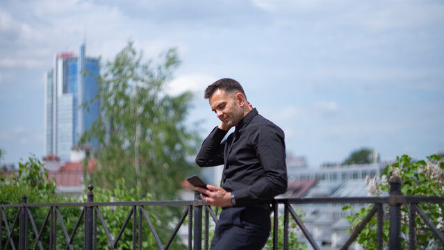 Relieved businessman looking at smartphone screen on city background with copy space