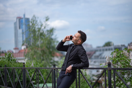 Confident businessman having phone call on city background with copy space