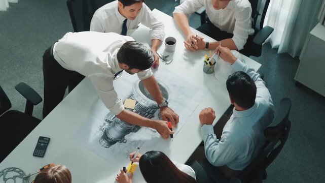 Top view of professional engineer showing and talking about turbine engine design. Aerial view of skilled designer or technician group explain about electronic generator construction. Alimentation.